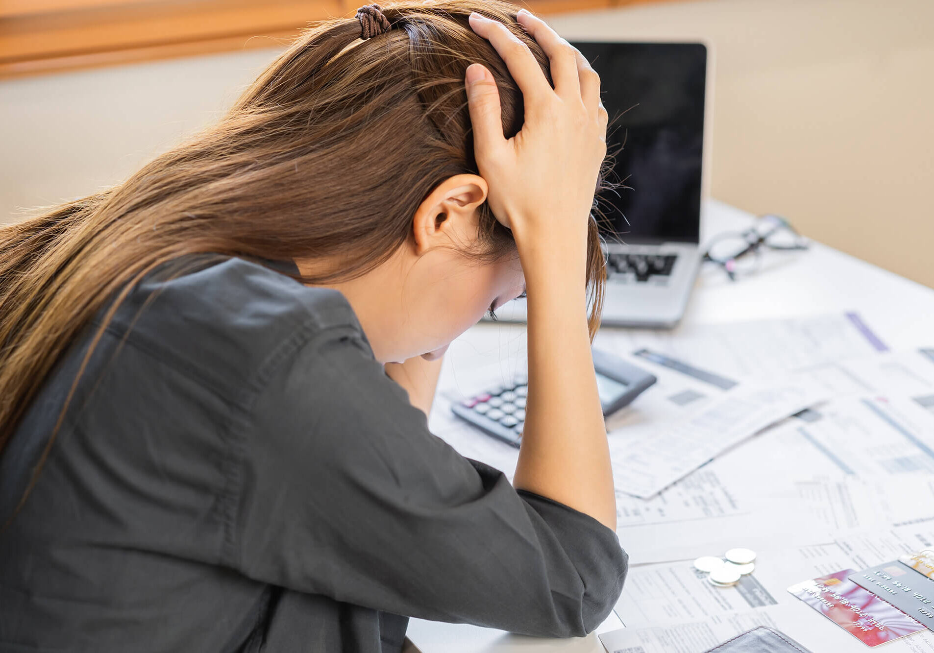 Financial owe asian woman sitting cover head with hands, stressed by calculate expense from invoice or bill, have no money to pay, mortgage or loan. Debt, bankruptcy or bankrupt concept.